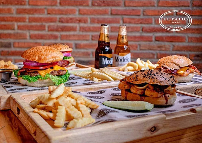 Charola con hamburguesas, papas y cervezas de El Patio de Beto