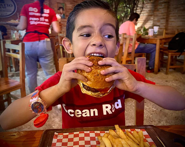 Niño comiendo una hamburguesa en El Patio de Beto